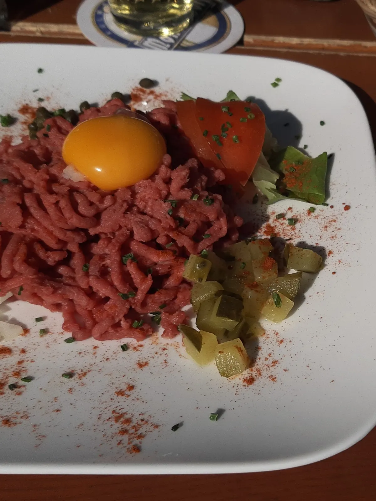 Bord met tartaar, een eidooier en augurken