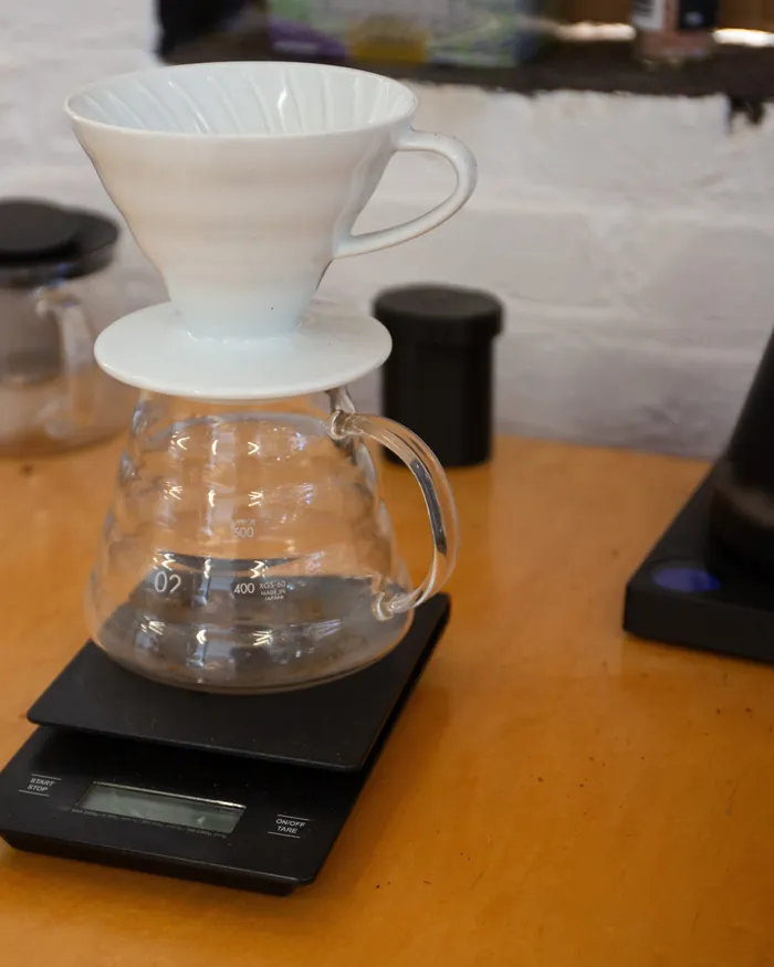 Witte keramische handfilter op een glazen kan